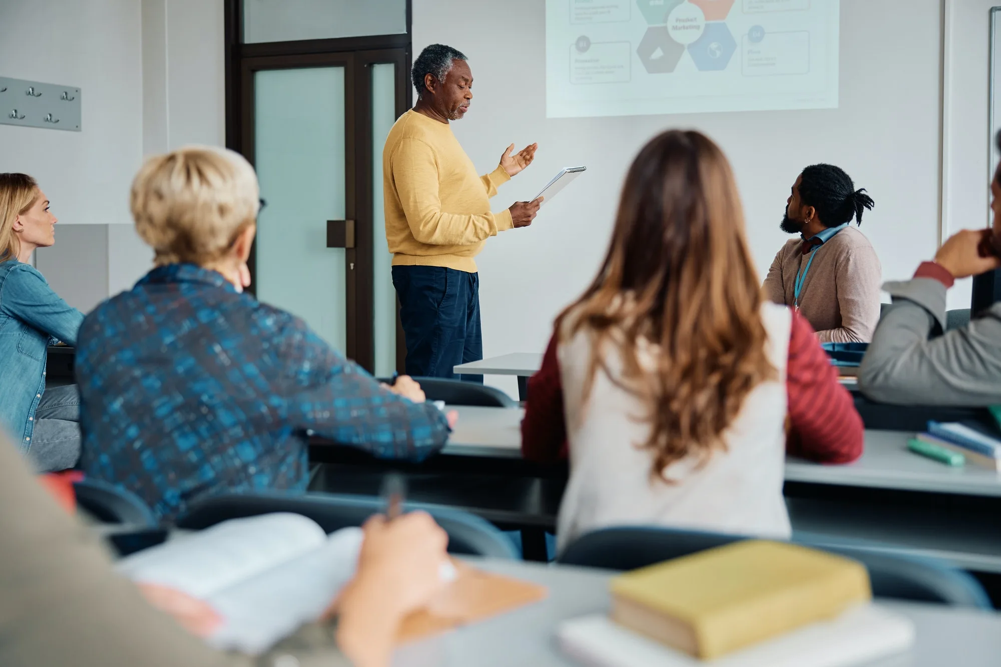 black senior man giving a presentation during education training class in lecture hall 