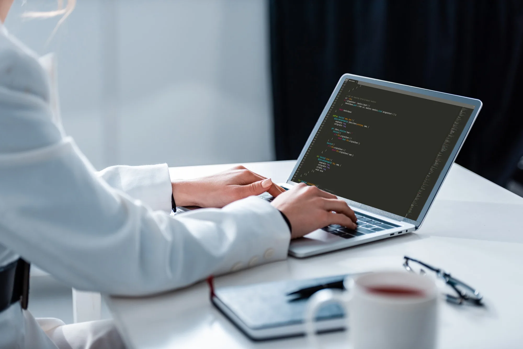 cropped view of woman using laptop with microsoft windows on screen at office desk