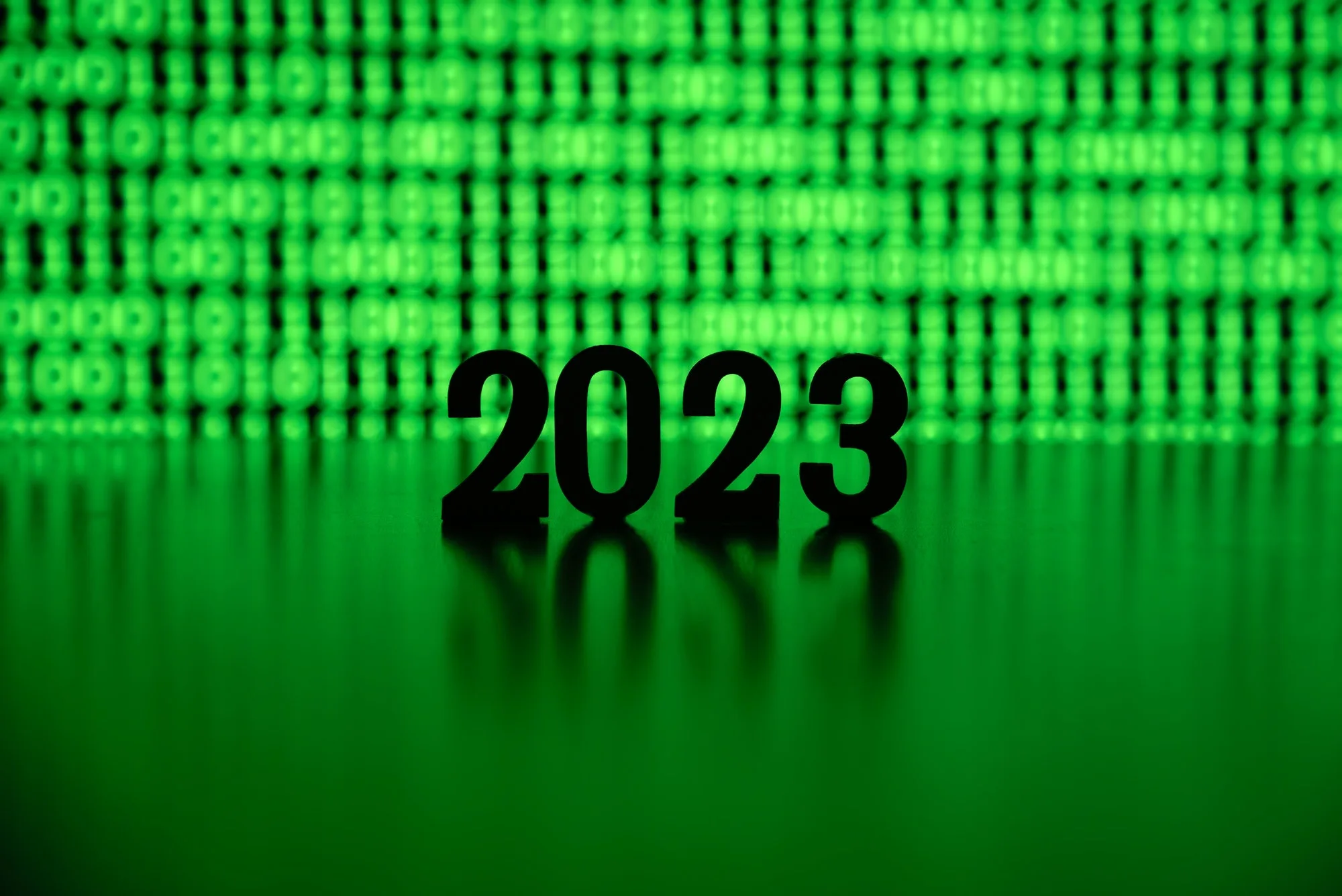 year 2023 backlit by green binary code